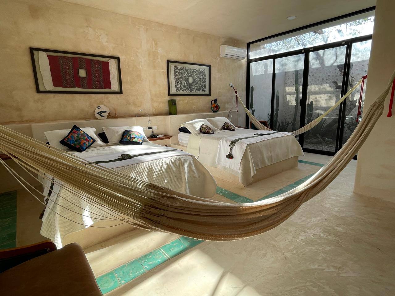 Suite Cactus con dos camas, hamaca y ventanal al jardín interior